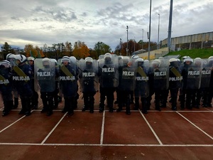 na zdjęciu policjanci podczas ćwiczeń z tarczami na stadionie