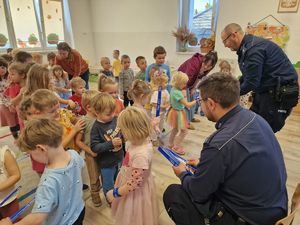 na zdjęciu policjanci rozdają dzieciom odblaski