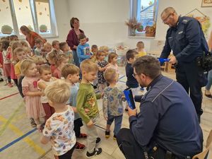 na zdjęciu policjanci dzieci otrzymują odblaski od policjantów