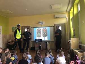 na zdjęciu policjanci przedstawiają dzieciom prezentacje