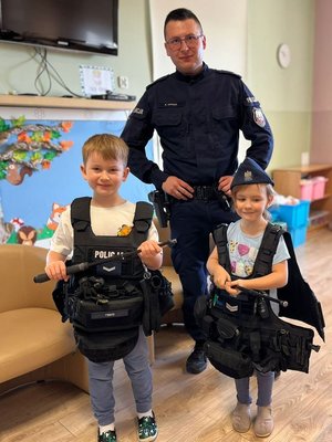 na zdjęciu dzieci ubrane w kamizelkę policyjną