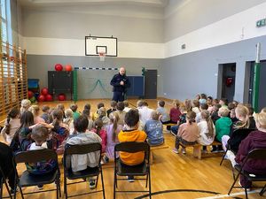 na zdjęciu policjant prowadzi pogadankę