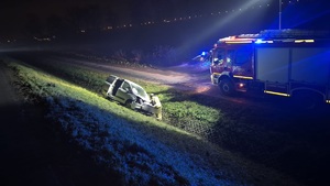 na zdjeciu samochód w rowie i straz pozarna udzielajaca pomocy