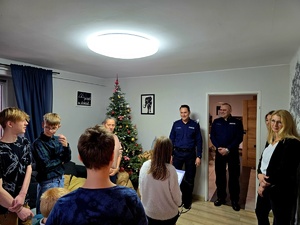 na zdjęciu komendant wręcza słodycze dzieciom