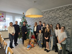 na zdjęciu komendant z policjantami i dziećmi zdjęcie grupowe