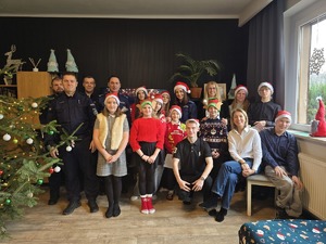 na zdjęciu komendant z policjantami i dziećmi zdjęcie grupowe