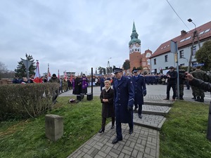 na zdjęciu komendant oraz pani Stefania pak idą odsłonić pomnik