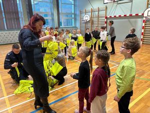 na zdjęciu dzieciom są rozdawane torby odblaskowe