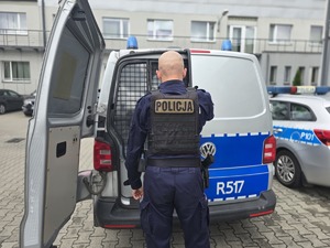na zdjęciu policjant przy radiowozie