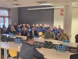 Zdjęcia kolorowe, na zdjęciu znajdują się uczestnicy odprawy rocznej, w tym kierownictwo raciborskiej jednostki tj. mł. insp. Tomasz Hynek oraz mł. insp. Mirosław Mielańczyk oraz KWP w Katowicach nadinsp. Mariusz Krzystyniak.