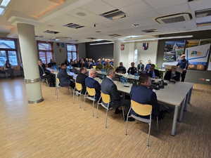 Zdjęcia kolorowe, na zdjęciu znajdują się uczestnicy odprawy rocznej, w tym kierownictwo raciborskiej jednostki tj. mł. insp. Tomasz Hynek oraz mł. insp. Mirosław Mielańczyk oraz KWP w Katowicach nadinsp. Mariusz Krzystyniak.