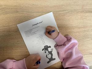 na zdjęciu dziewczynka rozwiązuje krzyżówkę