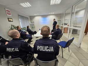 na zdjęciu kierownik przedstawia prezentacje