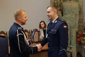 na zdjęciu komendant składa gratulacje