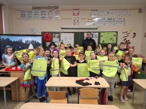 na zdjęciu policjant oraz uczniowie