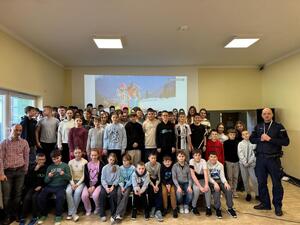 na zdjęciu policjant po zakończeniu prelekcji oraz uczniowie