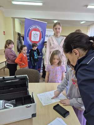 na zdjeciu policjantka pracownik sanepidu i dzieci podczas prelekcji
