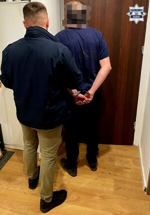 na zdjeciu zatrzymany poszukiwany stoi tyłem