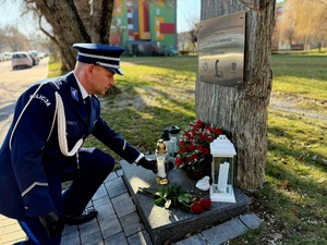 na zdjęciu komendant składa znicz pod obeliskiem