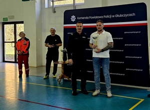 na zdjęciu policjant odbiera puchar za 3 miejsce