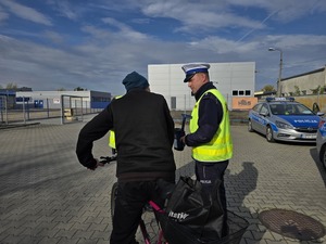 na zdjęciu rowerzysta i policjant