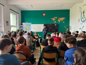 na zdjęciu policjant i uczniowie