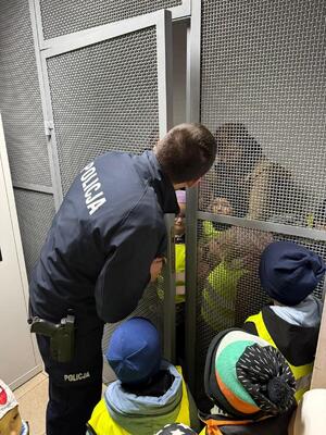 na zdjęciu widzimy dzieci które oglądają komisariat i rozmawiają z policjantami