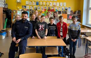 na zdjęciu policjant z uczniami