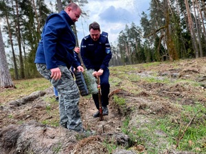 na zdjęciu komendant ze starosta nosi sadzonki