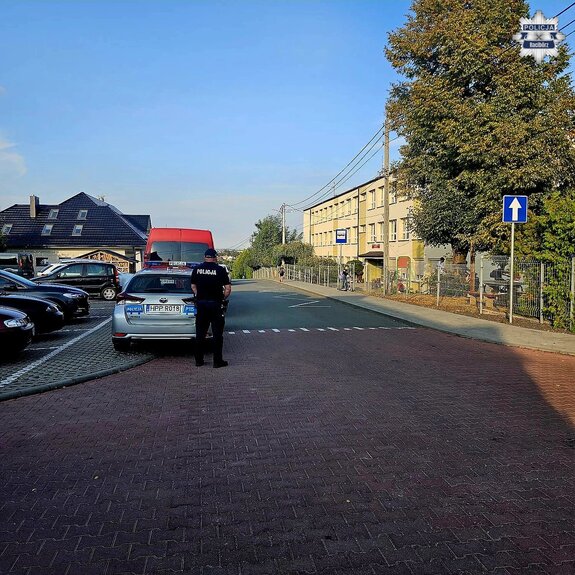 na zdjęciu policjant przy szkole