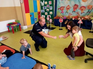 na zdjęciu policjant i przedszkolak wręcza mu laurkę
