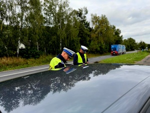 NA ZDJĘCIU POLICJANCI PRZEPROWADZAJA KONTROLE DROGOWĄ