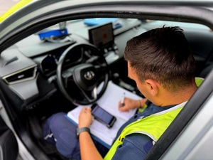 NA ZDJĘCIU POLICJANT ZAPISUJE W NOTATNIKU SLŻBOWYM